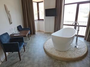 斯基希德尼萨Osonnya Karpaty RESORT MEDICAL & SPA的带浴缸、椅子和桌子的浴室