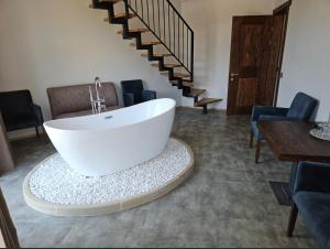 斯基希德尼萨Osonnya Karpaty RESORT MEDICAL & SPA的白色浴缸位于带楼梯的房间