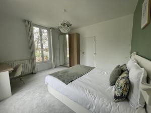 勒芒Villa Isaac - Luxueuse - Parking - 16p - Rêve au Mans的卧室配有白色的床和吊灯。