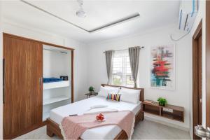 班加罗尔Olive Serviced Apartments BTM Layout的一间卧室设有一张床和一个窗口