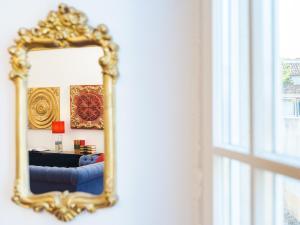 奥比多斯Casa Senhoras Rainhas - Óbidos - by Unlock Hotels的客厅里一面镜子,一面蓝色的沙发