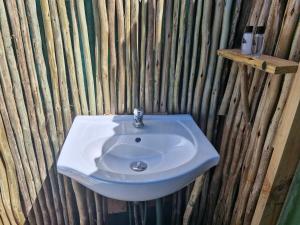 阿多Harmony Luxury Tents & Safari的一间带白色水槽和木墙的浴室