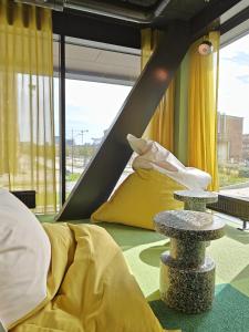 马尔默Basecamp Malmö的客房设有床和带黄色枕头的桌子。