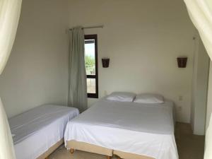 São Gonçalo do AmaranteCasa em resort na Taiba的白色客房的两张床,设有窗户