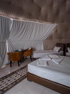 瓦迪拉姆RUM MAGiC lUXURY CAMP的客房设有两张床、一张桌子和一张书桌