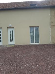 Saint-Hilaire-Petitvillegîte Mouettes et Chouettes的两扇窗户和砂石车道的房子