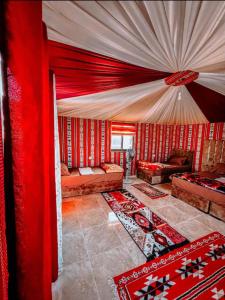 瓦迪拉姆RUM MAGiC lUXURY CAMP的客厅设有红色的墙壁和红色的窗帘