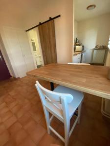 维逊拉洛梅尼Le Moulin de César的厨房里配有一张木桌和一张白色椅子