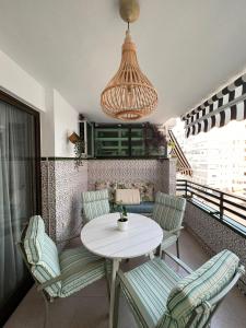 马拉加Apartamento Parque Mediterráneo的阳台配有桌椅和吊灯。