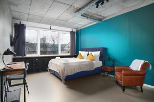 莱比锡Stylisches Studio im Herzen Leipzigs的卧室拥有蓝色的墙壁,配有一张床和椅子