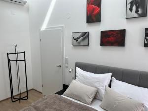 梅尔克Haus Fünf mit 2 Apartments und Studio-Loft mit Terrasse的一间卧室配有一张床,墙上挂着一些图片