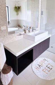 托基Torquay's All Seasons Pool & Spa Retreat的浴室设有白色水槽和镜子