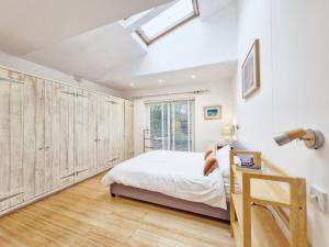 埃姆斯沃思Primrose Cottage的一间卧室配有一张床和木制衣柜