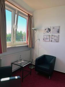 沙博伊茨Zeitlos Hotel Garni的客厅配有桌子、椅子和灯