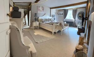 CrowhurstChurch Farmhouse, Surrey, Sleeps 10, Large Garden的一间大卧室,配有一张床和一把椅子