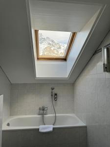 格林德尔瓦尔德里斯登公寓酒店的带浴缸和窗户的浴室