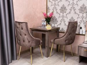 奇姆肯特Stela Hotel的一张桌子,两把椅子,一张桌子,花瓶