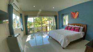 甲米镇Lay Back Villa C1with kitchen & High Speed Internet的一间卧室配有带粉红色枕头的床和阳台