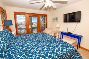 科罗拉OS2J, Jeanes Dream- Oceanside, Hot Tub, Lake Views!的一间卧室配有蓝色的床和吊扇