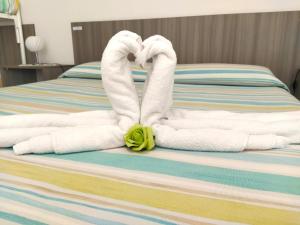 乌真托B&B Incanto Salento的一张带毛巾的床,形状像天鹅
