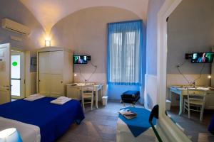 托雷安农齐亚塔Il Giardino di Tonia - Oplontis Guest House - Bed & Garden -的酒店客房带两张床和一张桌子以及椅子。