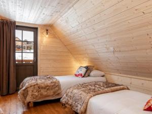 拉茹杜罗普SUNWEB L'Ecrin des Neiges的木墙客房的两张床