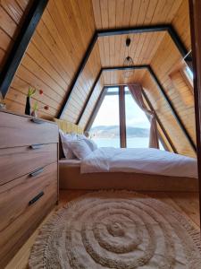 皮亚特拉-尼亚姆茨Chalet by the lake的一间卧室设有一张大床和大窗户