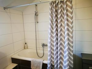 凯撒斯劳滕Ferienwohnung am Waldpfad的浴室设有带浴帘的浴缸