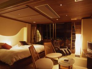 加贺叶渡莉日式旅馆的一间卧室配有一张床、椅子和电视