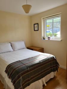 韦斯特波特Quay village 16的一间卧室设有一张床和一个窗口