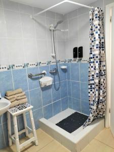 洛斯克里斯蒂亚诺斯Port Royale Los Cristianos的蓝色和白色的浴室设有淋浴和凳子