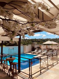 瓦索拉斯Bliss Hotel Vale do Café的一个带桌椅的庭院和一个游泳池