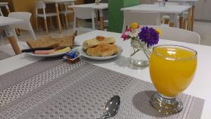 门多萨Nómade Hostel mdz的一张桌子,上面放着一杯橙汁和一盘食物