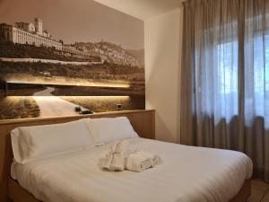 阿西西克拉丹酒店的一间卧室配有带毛巾的床