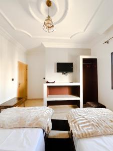 达赫拉Hotel Ahmed Ali的一间卧室设有两张床,天花板上配有电视。