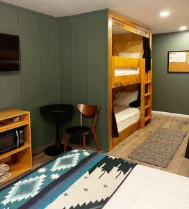 派恩代尔Jackalope Motor Lodge的卧室配有双层床、桌子和椅子
