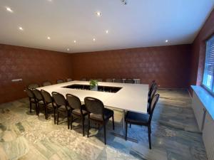 吕德斯海姆莱因斯坦酒店的一间会议室,配有白色的桌子和椅子