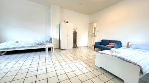 新明斯特Unterkunft mit Einzelzimmer Zentrum的客房设有两张床、一张沙发和一台冰箱。