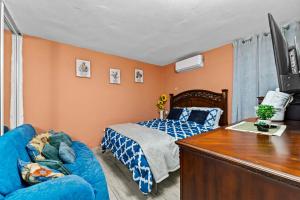 林康Lupa Guesthouse affordable family home的一间卧室配有一张床和一张蓝色的沙发