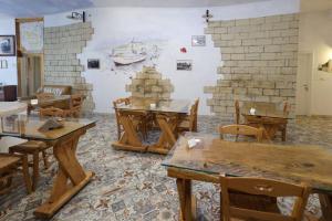 莫尔恰诺迪莱乌卡Antico Borgo Marchese的配有木桌、椅子和墙壁的客房