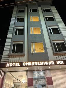德奥加尔Hotel Omkareshwar Inn的荒野上的酒店,前面有标志