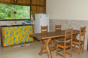 大塞拉Sitio recanto da natureza的厨房配有木制桌椅和冰箱