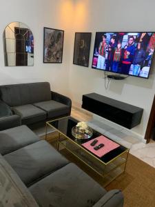 BrusubiThe Retreat Apartments的带沙发和平面电视的客厅