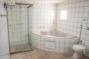 PenápolisSakr Hotel的带浴缸、卫生间和淋浴的浴室。