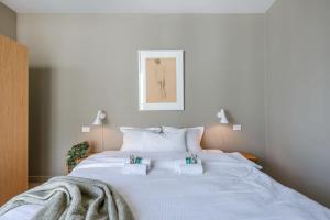 布鲁日Bonrepo Room 103的一张白色的大床,带两条毛巾