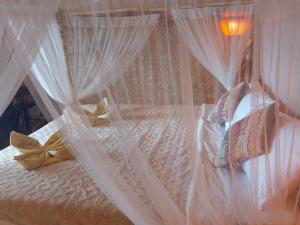 圣维森特Jungle Bar Honeymoon suite & private pool的一张带白色窗帘和枕头的床