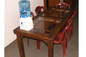 阿努拉德普勒Leaf Dew Resort的一张木桌,上面有一瓶水
