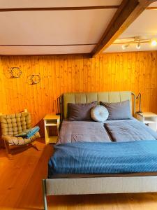 坎德施泰格Lovely & great equipped wooden Alp Chalet flat的一间卧室配有一张大床和一把椅子
