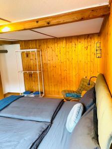 坎德施泰格Lovely & great equipped wooden Alp Chalet flat的木墙客房的一张床位