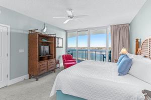 奥兰治比奇Caribe Resort Unit B603的一间卧室设有一张床、一台电视和一个窗口。